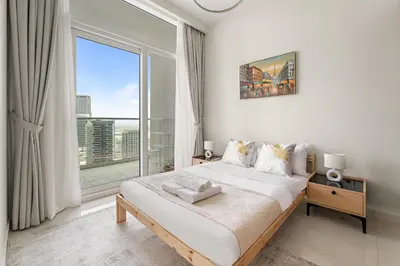 a bedroom with a bed and a large window at Cozy 1BR at Reva Residences in Dubai