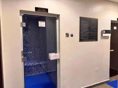 a shower with a blue floor and a door at Cozy 1BR at Reva Residences in Dubai