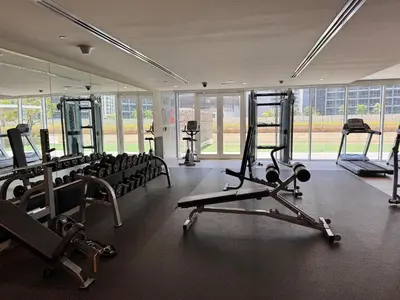 a gym with rows of treadmills and machines at Cozy 1BR at Reva Residences in Dubai