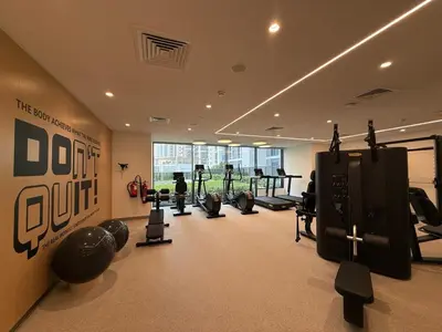 a gym with a bunch of equipment in a room at Island Park Comfort Stay in Dubai
