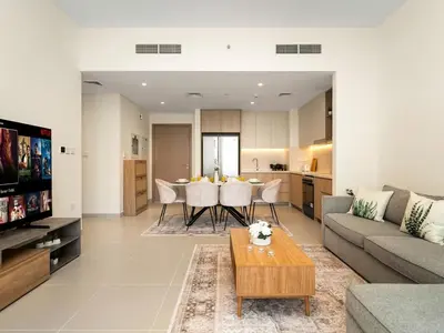 a living room with a couch and a table at Island Park Comfort Stay in Dubai