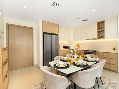a dining room with a table and chairs in a kitchen at Island Park Comfort Stay in Dubai