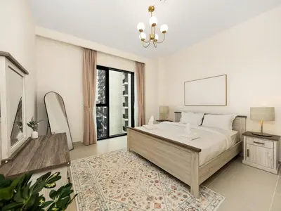 a bedroom with a large bed and a chandelier at Island Park Comfort Stay in Dubai