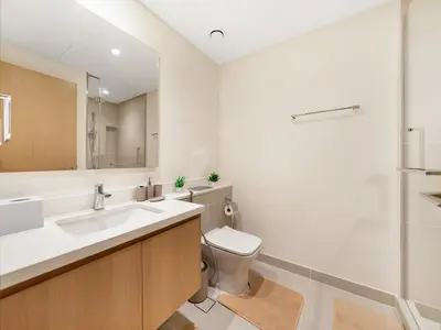 a bathroom with a toilet and a sink and a mirror at Island Park Comfort Stay in Dubai
