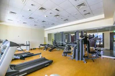 a gym with treadmills and elliptical machines at Luxury 1BR with Pool, Gym Canal & Burj Khalifa view in Dubai