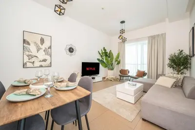 a living room with a table and a couch at Luxury 1BR with Pool, Gym Canal & Burj Khalifa view in Dubai