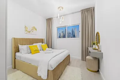 a bedroom with a large bed with yellow pillows at Stylish Apartment with Pool, Gym and Skyline View Dubai Gate in Dubai