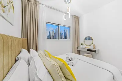 a bedroom with a bed with a yellow blanket at Stylish Apartment with Pool, Gym and Skyline View Dubai Gate in Dubai