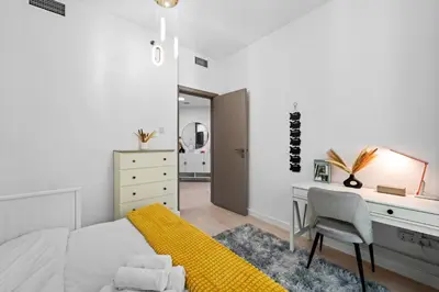 a bedroom with a bed and a desk and a chair at Stylish Apartment with Pool, Gym and Skyline View Dubai Gate in Dubai