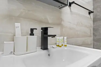 a bathroom with a sink with a faucet and towels at Stylish Apartment with Pool, Gym and Skyline View Dubai Gate in Dubai