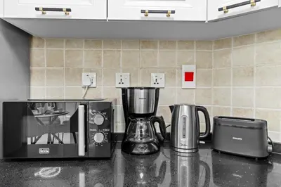 a kitchen counter with two coffee makers and a blender at Stylish Apartment with Pool, Gym and Skyline View Dubai Gate in Dubai