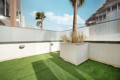 a courtyard with grass and a palm tree on a building at Downtown culture village escape in Dubai