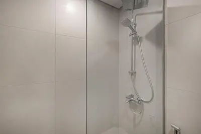 a bathroom with a shower with a glass door at Downtown culture village escape in Dubai