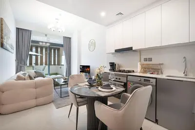a kitchen and living room with a table and chairs at Downtown culture village escape in Dubai