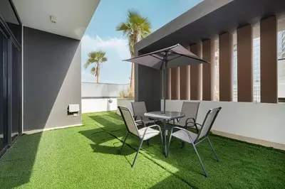 a patio with a table and chairs and an umbrella at Downtown culture village escape in Dubai