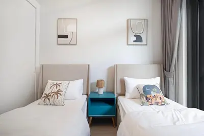 two beds sitting next to each other in a bedroom at Downtown culture village escape in Dubai