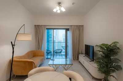 a living room with a couch and a tv at Modern 1BR - Fitness & Swimming Pool Access in Dubai