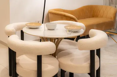 a table and chairs with bowls and cups on it at Modern 1BR - Fitness & Swimming Pool Access in Dubai