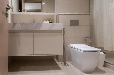 a white bathroom with a sink and a toilet at Modern 1BR - Fitness & Swimming Pool Access in Dubai