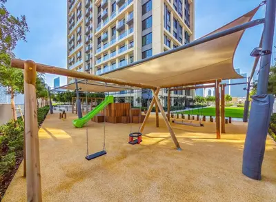 a playground with a swing in a building at Modern 1BR - Fitness & Swimming Pool Access in Dubai