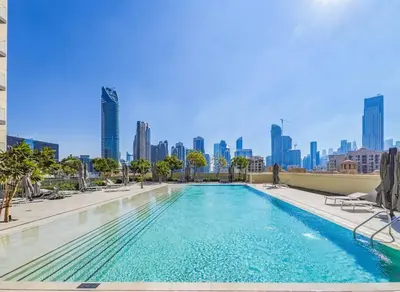 a swimming pool with a city skyline in the background at Modern 1BR - Fitness & Swimming Pool Access in Dubai