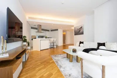 a living room with a white couch and a table at Spacious Luxury 1BR Modern Design Bluewaters in Dubai