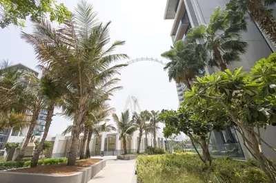 a row of palm trees in front of a building at Spacious Luxury 1BR Modern Design Bluewaters in Dubai