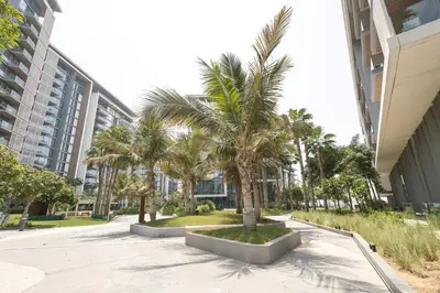 a row of palm trees in front of a building at Spacious Luxury 1BR Modern Design Bluewaters in Dubai