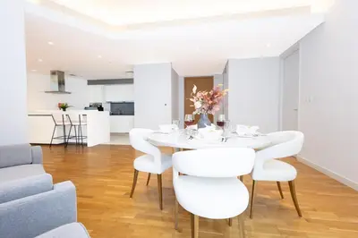 a dining room with a white table and white chairs at Spacious Luxury 1BR Modern Design Bluewaters in Dubai
