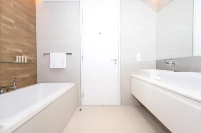 a white bathroom with a tub and a sink at Spacious Luxury 1BR Modern Design Bluewaters in Dubai