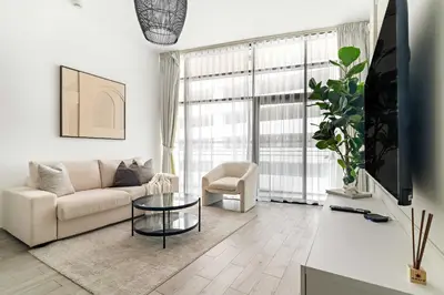 a living room with a couch and a table at Silkhaus Classic 1BDR Stay in Jumeirah Village in Dubai