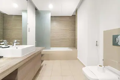 a bathroom with a sink and a tub and a toilet at Silkhaus Classic 1BDR Stay in Jumeirah Village in Dubai