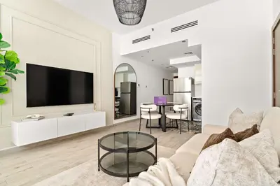 a living room with a couch and a tv at Silkhaus Classic 1BDR Stay in Jumeirah Village in Dubai