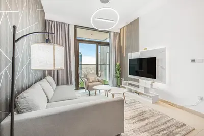a living room with a couch and a tv at Modern 1BR apartment in Burj Crown in Dubai