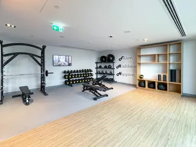 a gym with two treadmills and benches in a room at Modern 1BR apartment in Burj Crown in Dubai