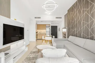a living room with a couch and a tv at Modern 1BR apartment in Burj Crown in Dubai
