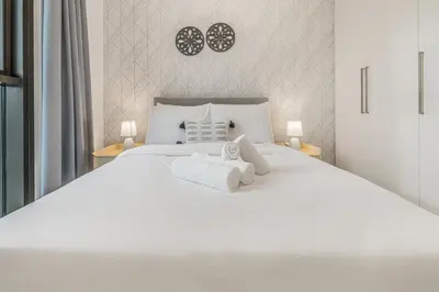 a bedroom with a white bed with towels on it at Modern 1BR apartment in Burj Crown in Dubai