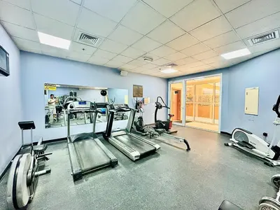a gym with treadmills and machines in a room at Homes2Retreat - JVC Charm - 1BR Apt with Private Balcony in Dubai