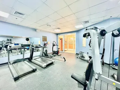 a gym with several tread machines in a room at Homes2Retreat - JVC Charm - 1BR Apt with Private Balcony in Dubai