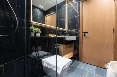 a bathroom with a toilet and a sink at TRPS - Binghatti Onyx JVC - Luxury 2BR with Private Pool in Dubai