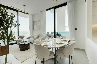 a white living room with a table and chairs at TRPS - Binghatti Onyx JVC - Luxury 2BR with Private Pool in Dubai