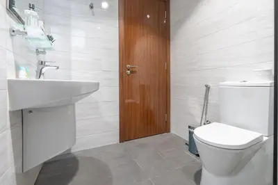 a bathroom with a white toilet and a sink at Dunya Tower Downtown 1BR Balcony Pool View 2Min to Dubai Mall in Dubai