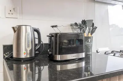 a kitchen counter with a toaster and a coffee maker at Dunya Tower Downtown 1BR Balcony Pool View 2Min to Dubai Mall in Dubai