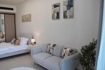 a living room with a couch and a bed at Binghatti Dusk Studio with Gym &Pool in Dubai