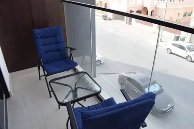 two chairs on a balcony with a view of a street at Binghatti Dusk Studio with Gym &Pool in Dubai