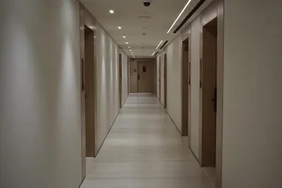 an empty corridor in a building with white walls and wooden floors at Binghatti Dusk Studio with Gym &Pool in Dubai