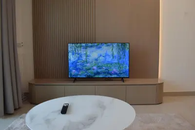 a living room with a tv and a white tub at Binghatti Dusk Studio with Gym &Pool in Dubai