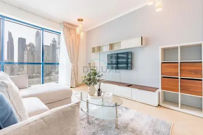 a living room with a couch and a tv at Spacious 1BR Overlooking City Skyline and Marina, Next to JLT Lakefront, Just Minutes to Metro, Jumairah Bay Tower X1, JLT by Deluxe Holiday Homes in Dubai