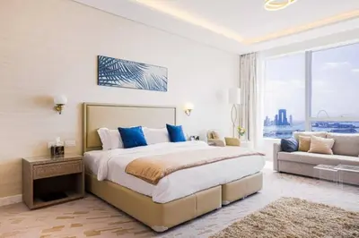 a bedroom with a large bed and a couch at Scenic Studio at Palm Tower in Dubai