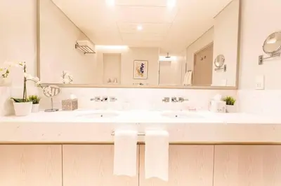 a bathroom with two sinks and a large mirror at Scenic Studio at Palm Tower in Dubai